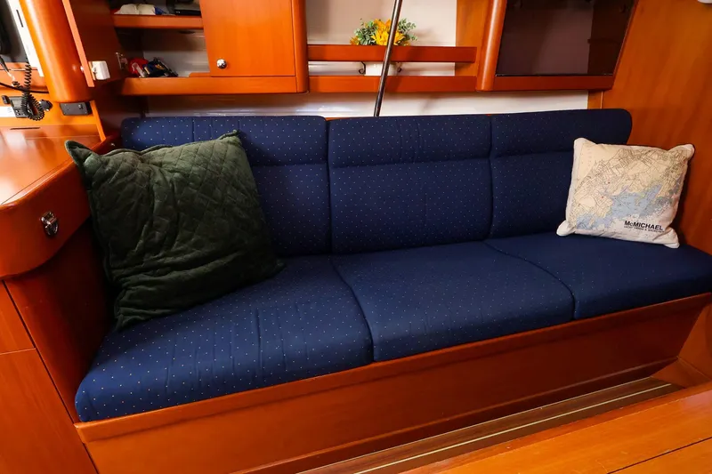 Slide: The Image of 2005 J Boats J/133 interior with blue cushioned seating and decorative pillows. - 25