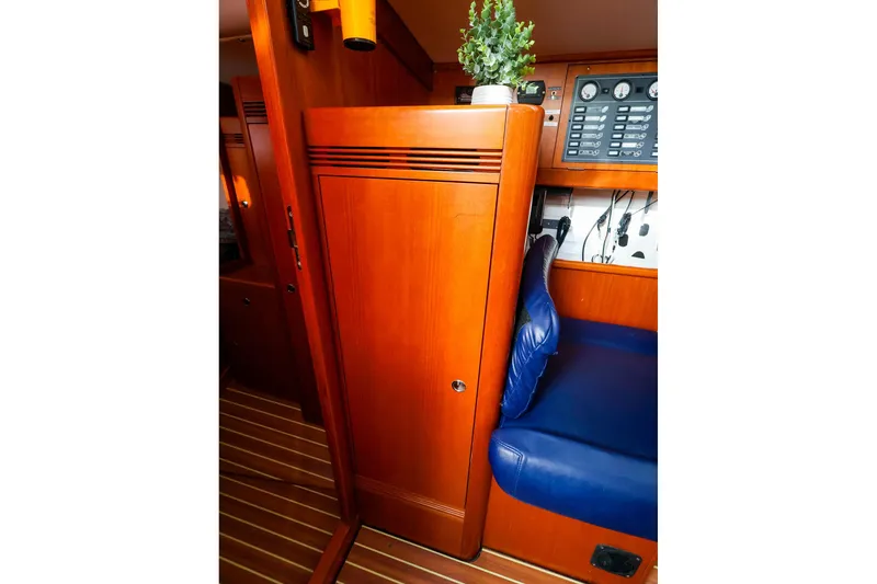 Slide: The Image of Interior of 2005 J Boats J/133, featuring wood paneling and blue seating. - 30