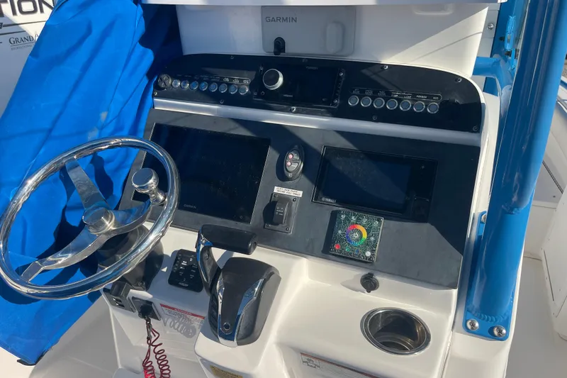 Slide: The Image of 2021 Everglades 243 Center Console boat dashboard with steering wheel and navigation controls. - 2