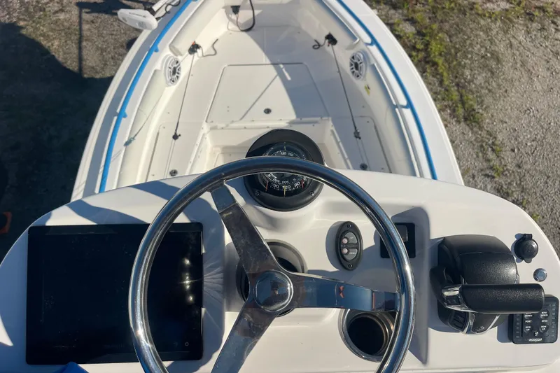 Slide: The Image of 2021 Everglades 243 Center Console boat dashboard with steering wheel and controls. - 27