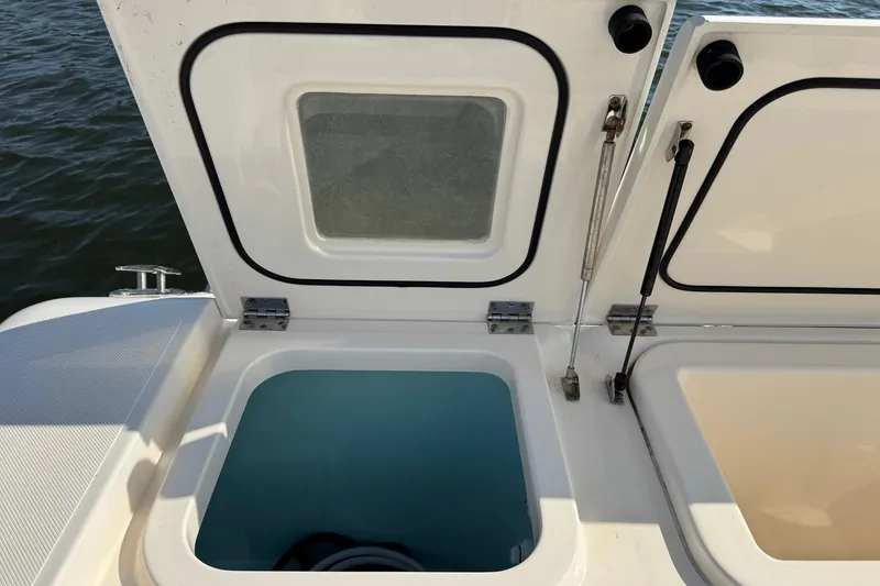 Slide: The Image of Open storage compartments on a 2011 Pursuit OS 375 Offshore boat, near water. - 13