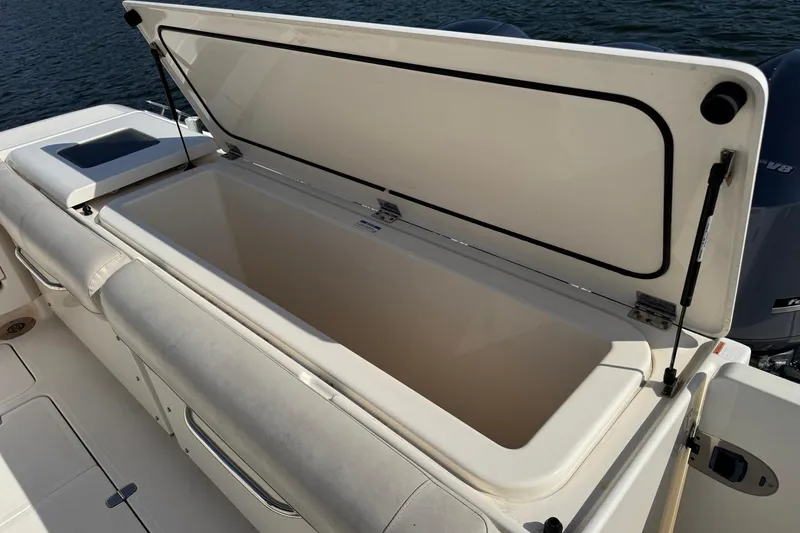 Slide: The Image of Open storage compartment on 2011 Pursuit OS 375 Offshore boat, near water. - 14