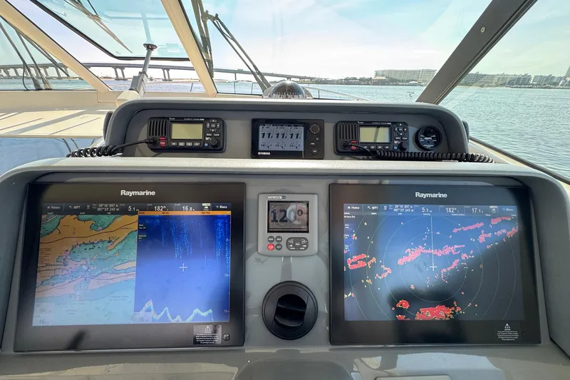 Slide: The Image of 2011 Pursuit OS 375 Offshore boat dashboard with Raymarine navigation displays. - 26