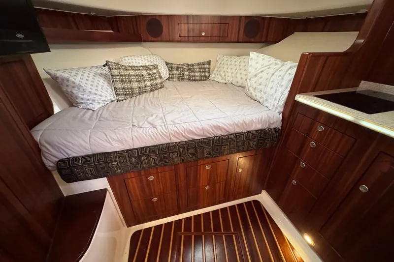 Slide: The Image of Luxurious cabin interior of 2011 Pursuit OS 375 Offshore with cozy bedding and wooden cabinetry. - 29