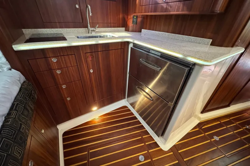 Slide: The Image of 2011 Pursuit OS 375 Offshore yacht kitchen with wood cabinetry and stainless steel appliances. - 30