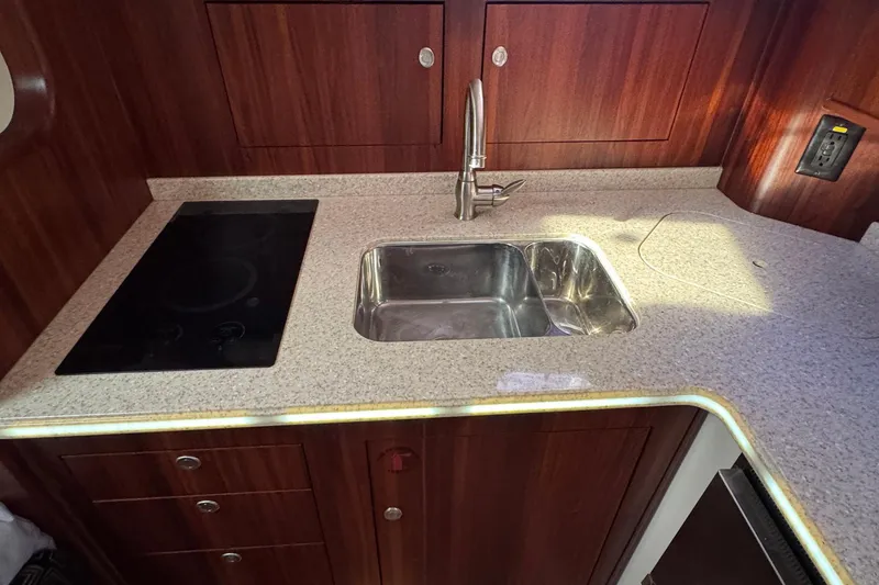 Slide: The Image of 2011 Pursuit OS 375 Offshore yacht kitchen with sink and stovetop. - 31