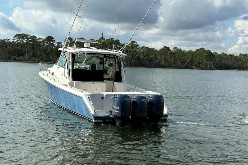 Slide: The Image of 2011 Pursuit OS 375 Offshore boat with triple Yamaha engines on a calm lake. - 5