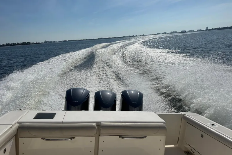 Slide: The Image of 2011 Pursuit OS 375 Offshore boat cruising, leaving a wake on a sunny day. - 9