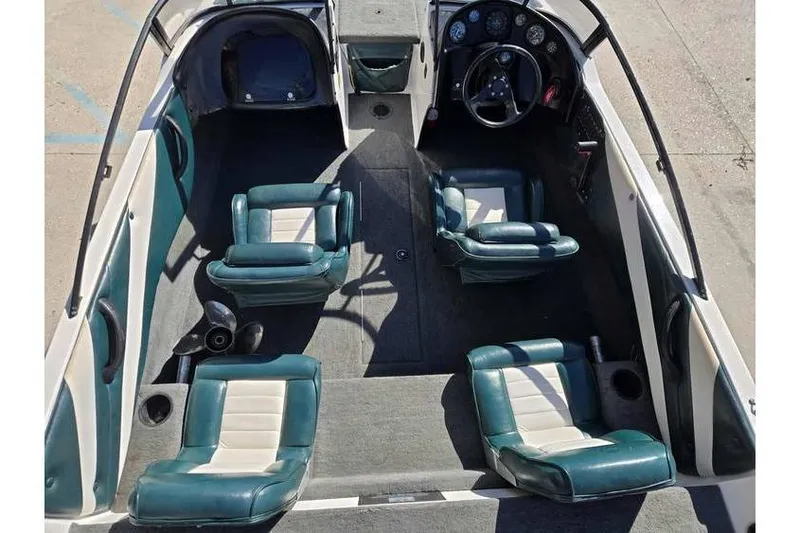 Slide: The Image of 1997 Javelin 389 FS boat interior with teal and white seating, steering wheel, and dashboard. - 11