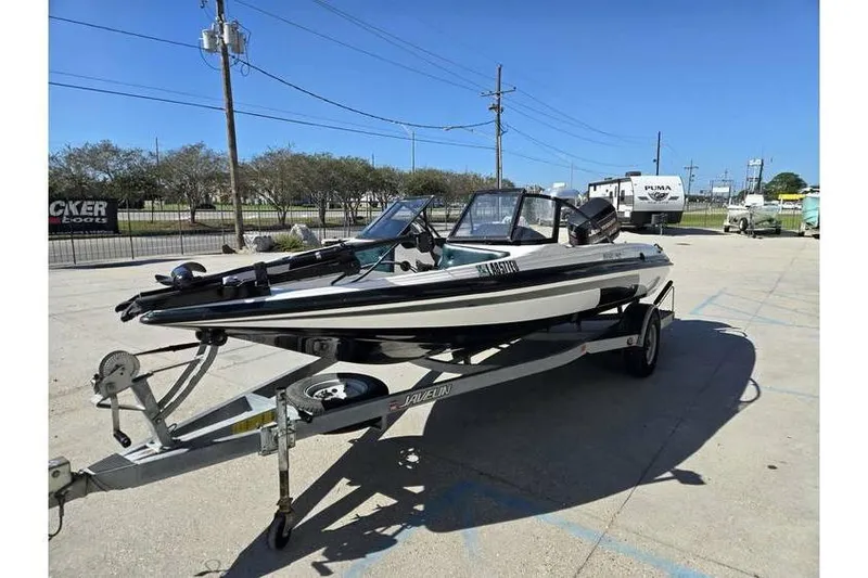 Slide: The Image of 1997 Javelin 389 FS boat on trailer in outdoor parking lot. - 4