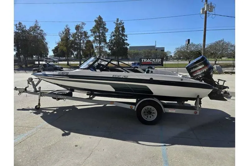 Slide: The Image of 1997 Javelin 389 FS boat on trailer with Johnson outboard motor, parked outdoors. - 5