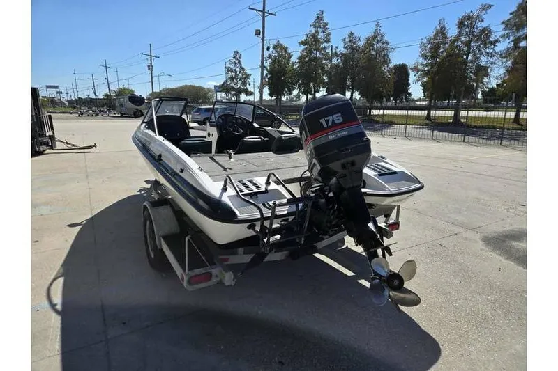 Slide: The Image of 1997 Javelin 389 FS boat with 175 horsepower motor on trailer, parked outdoors. - 6