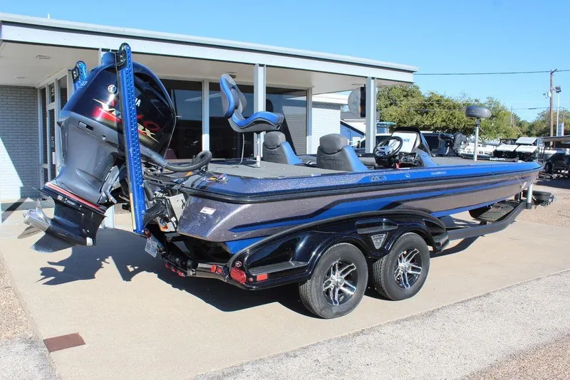Slide: The Image of 2016 Skeeter FX21 Limited Edition boat with dual axle trailer, parked outdoors. - 1