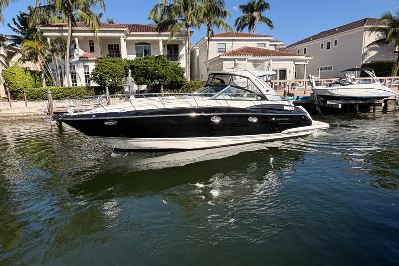 The Image of 2012 Monterey 400 Sport Yacht docked near waterfront homes. - 0