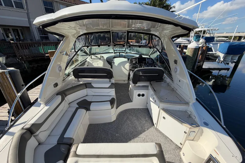 Slide: The Image of 2012 Monterey 400 Sport Yacht interior with seating and helm, docked by the water. - 14