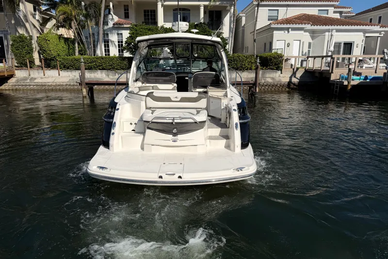 Slide: The Image of 2012 Monterey 400 Sport Yacht docked in a residential waterfront area. - 2