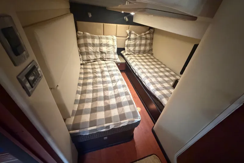 Slide: The Image of 2012 Monterey 400 Sport Yacht cabin with twin beds and checkered bedding. - 36