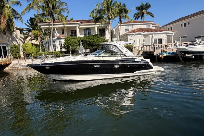 Slide: The Image of 2012 Monterey 400 Sport Yacht docked near waterfront homes with palm trees. - 4