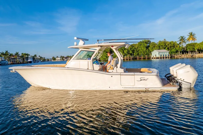 Slide: The Image of 2020 Scout 355 LXF boat cruising on a sunny day, featuring sleek design and powerful engines. - 13