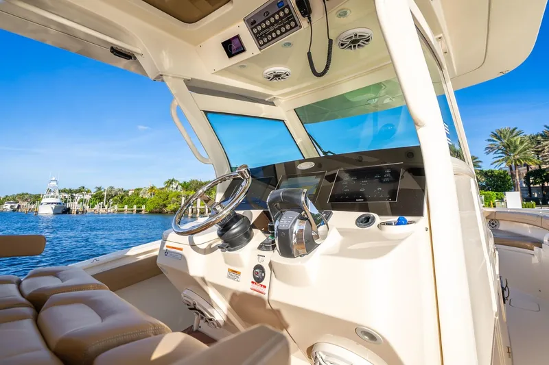 Slide: The Image of 2020 Scout 355 LXF boat cockpit with modern controls and scenic waterfront view. - 19