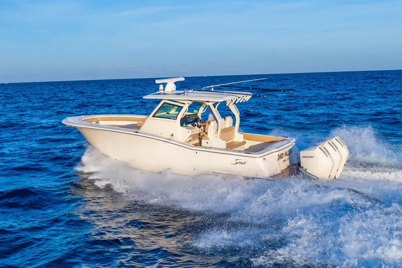 Slide: The Image of 2020 Scout 355 LXF boat cruising on open blue ocean waters. - 2