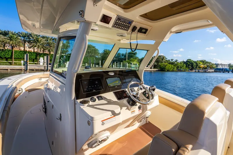 Slide: The Image of 2020 Scout 355 LXF boat interior with helm, steering wheel, and navigation screens. - 20