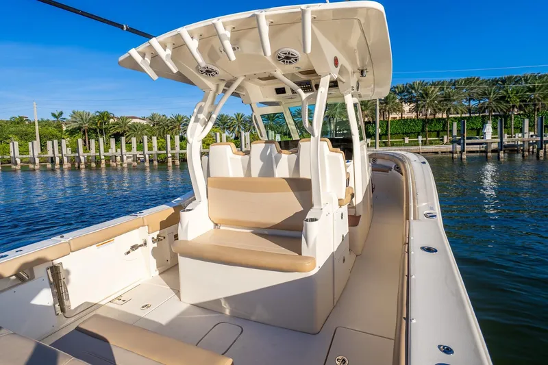 Slide: The Image of 2020 Scout 355 LXF boat with seating, docked by palm trees and clear blue water. - 24