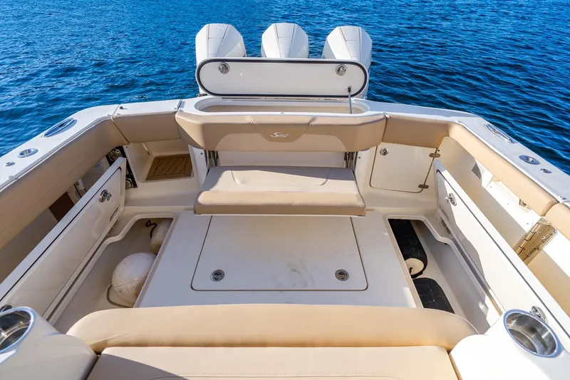 Slide: The Image of 2020 Scout 355 LXF boat interior with seating and storage, on blue water. - 27