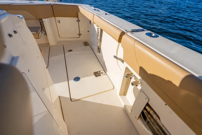 Slide: The Image of 2020 Scout 355 LXF boat interior with tan seating and storage compartments. - 28