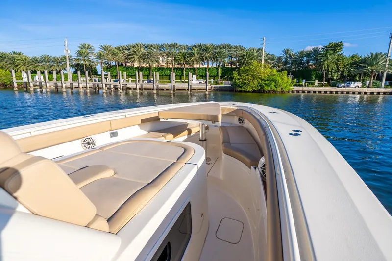 Slide: The Image of 2020 Scout 355 LXF boat with luxurious seating, dockside view, and palm trees in the background. - 30