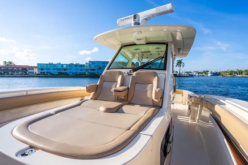 Slide: The Image of 2020 Scout 355 LXF luxury boat with comfortable seating, cruising on a sunny day. - 31