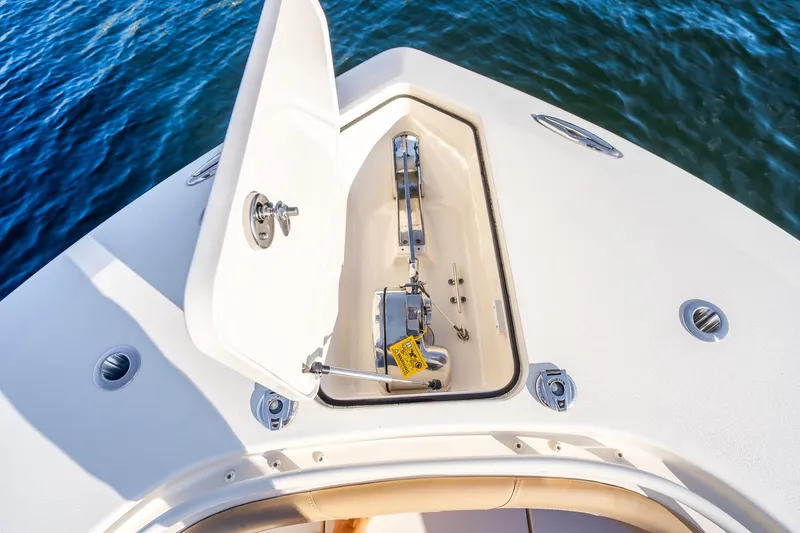 Slide: The Image of 2020 Scout 355 LXF boat anchor compartment open on calm water. - 34