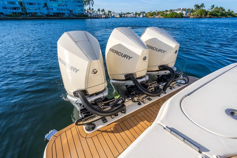 Slide: The Image of Triple Mercury outboard engines on 2020 Scout 355 LXF boat, docked on calm water. - 35