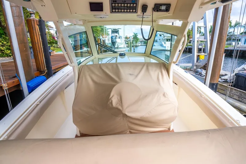 Slide: The Image of 2020 Scout 355 LXF boat interior with covered helm station and dock view. - 39