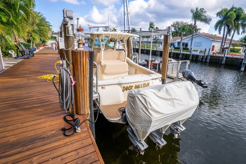 Slide: The Image of 2020 Scout 355 LXF boat docked by a wooden pier with palm trees. - 41
