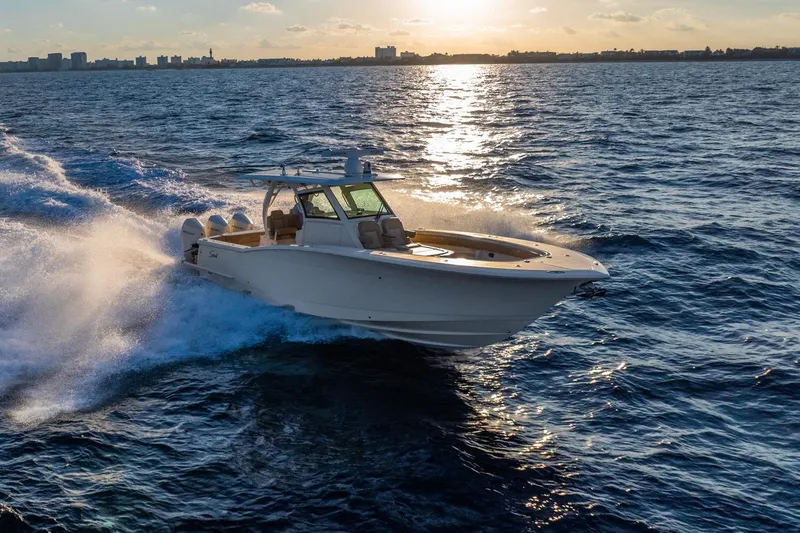 Slide: The Image of 2020 Scout 355 LXF boat cruising on ocean at sunset. - 5