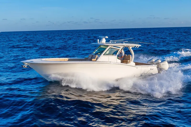 Slide: The Image of 2020 Scout 355 LXF boat cruising on open blue ocean waters. - 6