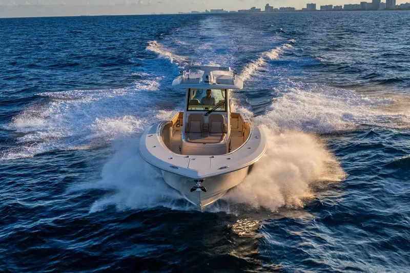 Slide: The Image of 2020 Scout 355 LXF boat cruising on open ocean waters. - 7