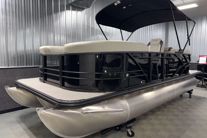 Slide: The Image of 2026 Sylvan Mirage X1 pontoon boat in a showroom, featuring sleek design and modern amenities. - 17