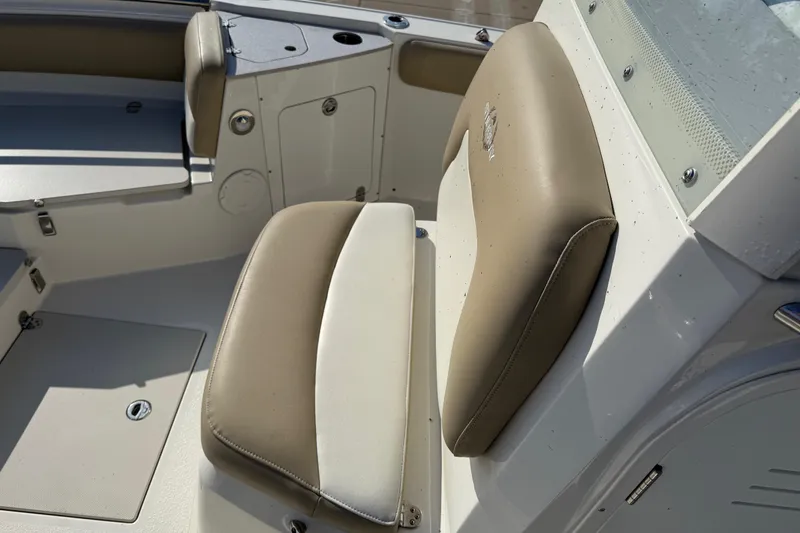 Slide: The Image of 2019 Stingray 236 CC boat interior with beige and white seating. - 11
