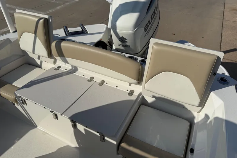 Slide: The Image of 2019 Stingray 236 CC boat interior with beige seating and Suzuki engine. - 13