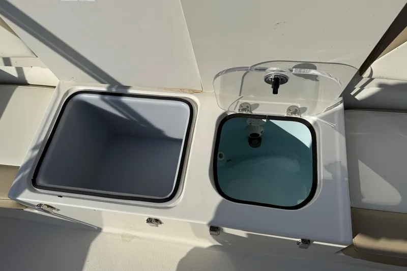 Slide: The Image of 2019 Stingray 236 CC boat storage compartments with open lids, showcasing interior space. - 14
