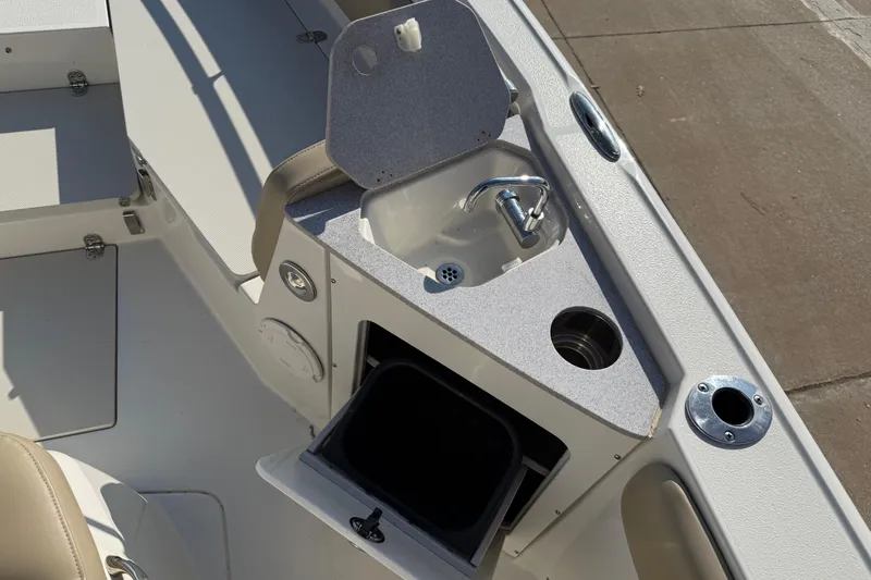 Slide: The Image of 2019 Stingray 236 CC boat interior with sink and storage compartment. - 18