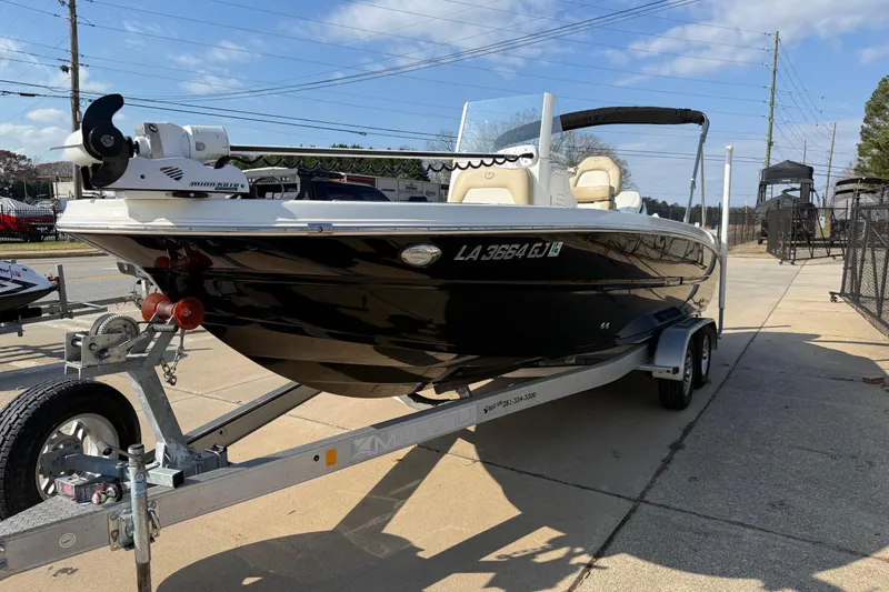 Slide: The Image of 2019 Stingray 236 CC boat on trailer, parked outdoors under clear sky. - 2