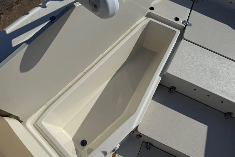 Slide: The Image of 2019 Stingray 236 CC boat storage compartment, open and empty, with white interior. - 21