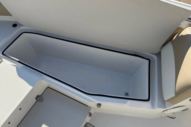 Slide: The Image of 2019 Stingray 236 CC boat storage compartment with open lid and drain plug. - 22