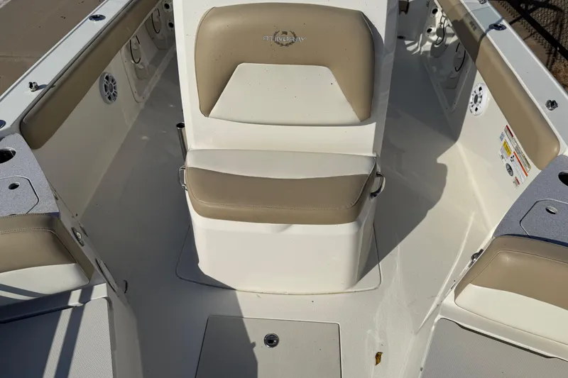 Slide: The Image of 2019 Stingray 236 CC boat interior with beige seating and white deck. - 27