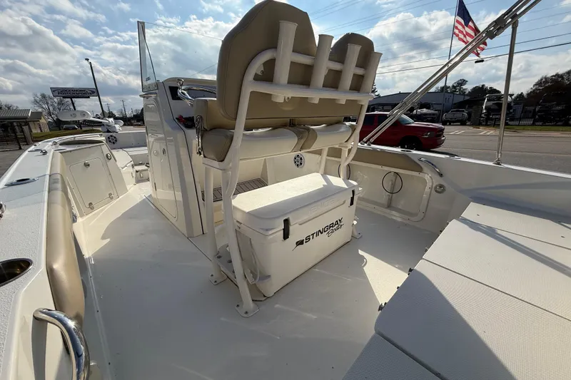 Slide: The Image of 2019 Stingray 236 CC boat interior with seating and storage, under a partly cloudy sky. - 32