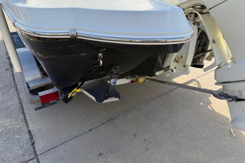 Slide: The Image of 2019 Stingray 236 CC boat on trailer, rear view showing motor and trim tabs. - 33