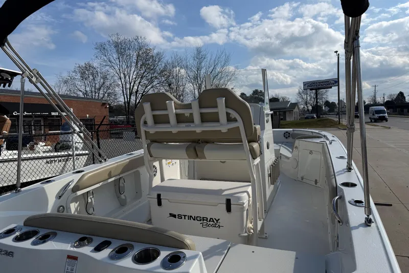 Slide: The Image of 2019 Stingray 236 CC boat interior with seating and storage, under a partly cloudy sky. - 35